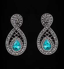 Image showing earring with colorful blue gems on black background