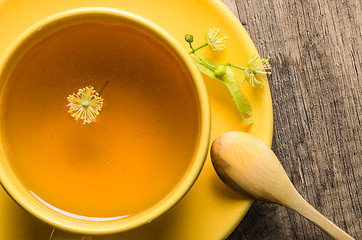 Image showing Yellow cup with linden tea on the table,  top view