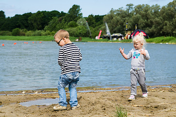 Image showing  Boy and girl playing in the sand on the shore of Lake 