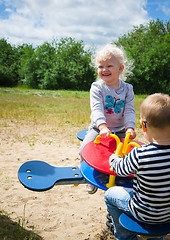 Image showing Boy and girl swinging on a swing