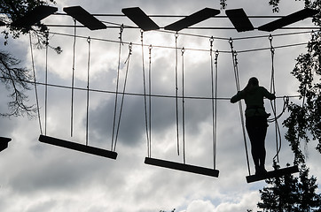 Image showing Silhouette of the girl on Dangerous ropeway with tether in rope 