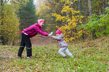 Image showing Woman with girl doing aerobics in the autumn park