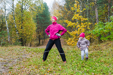 Image showing Woman with girl doing aerobics in the autumn park