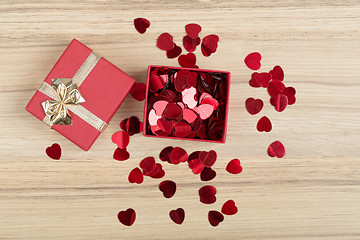 Image showing Red hearts confetti on wooden background