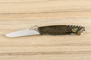 Image showing Multipurpose knife on wooden background