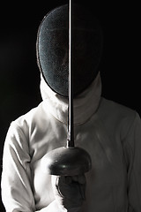 Image showing The portrait of woman wearing white fencing costume  on black 