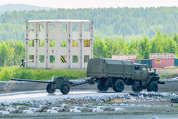 Image showing army truck transports gun after water ford