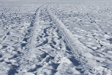 Image showing Wheel track and human footprints on the snow