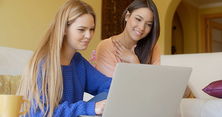 Image showing Two happy young women browsing the internet