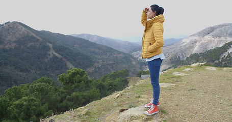 Image showing Young woman looking out over mountain scenery