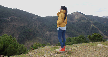 Image showing Woman in yellow coat near mountain valley