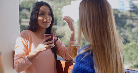 Image showing Young woman drinking coffee and using a mobile