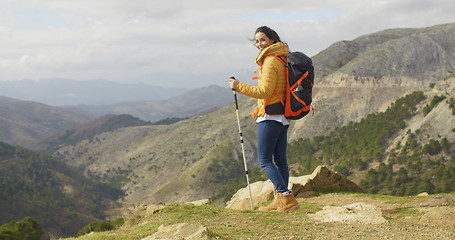 Image showing Young woman hiker standing overlooking a valley