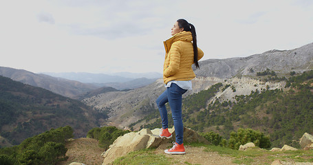 Image showing Woman in yellow coat near mountain valley