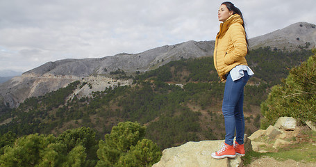 Image showing Woman in yellow coat near mountain valley