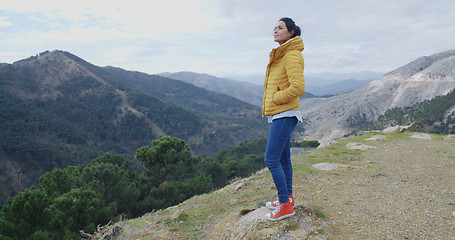 Image showing Woman in yellow coat near mountain valley
