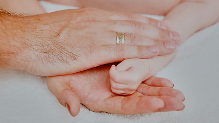 Image showing sleeping baby in hand of parent 