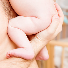 Image showing Closeup of baby hand into parents hands.