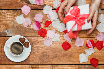Image showing Valentines Day gift and Female hands on wooden background 