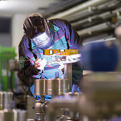 Image showing Industrial worker welding in metal factory.