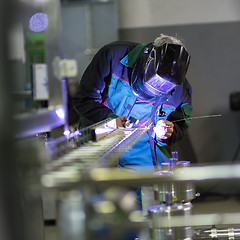 Image showing Industrial worker welding in metal factory.