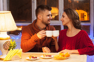 Image showing The  happy young couple with cups of tea 