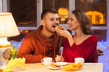 Image showing The  happy young couple with cups of tea 