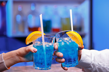 Image showing The hands with alcohol cocktails making toast on a bar background