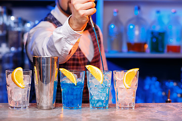 Image showing Barman at work, preparing cocktails.