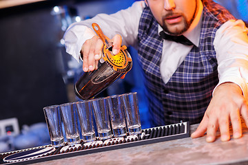 Image showing Barman at work, preparing cocktails.