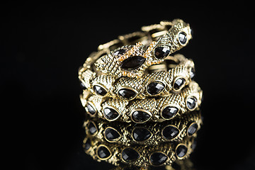 Image showing golden bracelet form of snake isolated black background