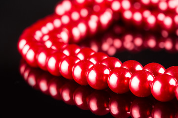 Image showing necklace of red pearls on black background