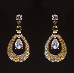 Image showing gold earrings with white little stones 