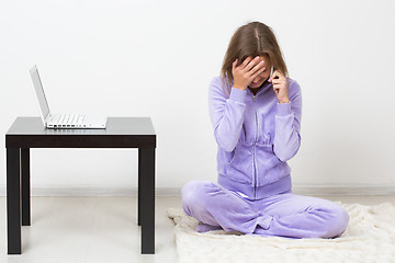 Image showing distraught woman talking on the phone while 