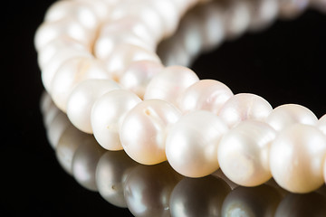 Image showing White pearls on  black  background. luxury necklace.