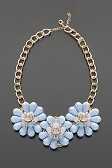 Image showing plastic necklace. three blue flower