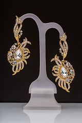 Image showing gold earrings with white little stones 