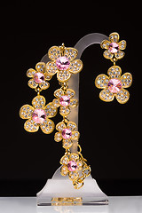 Image showing gold pendant and earrings in the shape of flowers