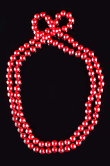 Image showing necklace of red pearls on black background