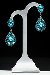 Image showing earrings with blue stones on the black 