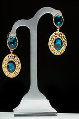 Image showing earrings with blue stones on the black 