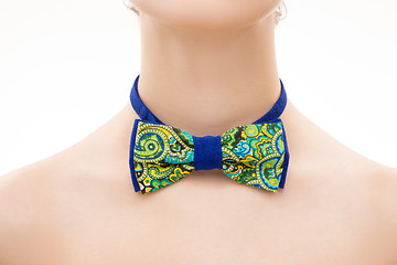 Image showing patterned tie bow on female neck. 