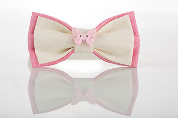 Image showing white bow tie with pink accents and a butterfly