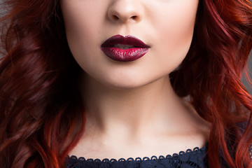 Image showing closeup cherry lips. girl with red hair. the lower part of the face. Fashion Girl Portrait.