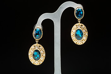 Image showing earrings with blue stones on the black 