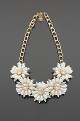 Image showing plastic necklace. five beige flower