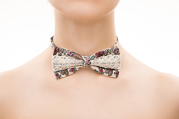 Image showing patterned tie bow on female neck. 