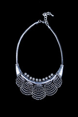 Image showing metal feminine necklace. on black background. 
