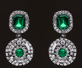 Image showing earrings with green stones on the black 