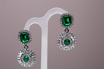 Image showing earrings with green stones on the gray